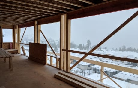 view of hills in winter Kamloops, BC from unfinished deck of Custom home with two saw horses