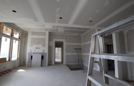 Ready for paint - great room with finished drywall view towards master bedroom